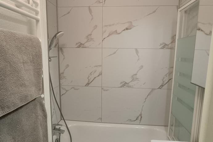 Salle de bain avec paroi de douche et sèche serviettes 