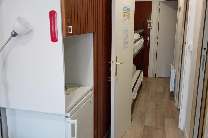 GRAND MEUBLE DE RANGEMENT + REFRIGERATEUR ET VUE SUR LE COULOIR AVEC LITS SUPERPOSES