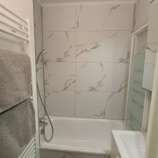 Salle de bain avec paroi de douche et sèche serviettes 