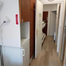 GRAND MEUBLE DE RANGEMENT + REFRIGERATEUR ET VUE SUR LE COULOIR AVEC LITS SUPERPOSES